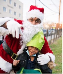 image of a man dressed up as Santa Claus with a young child posing for a picture