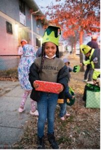Young girl with elf hat on showing off her christmas present